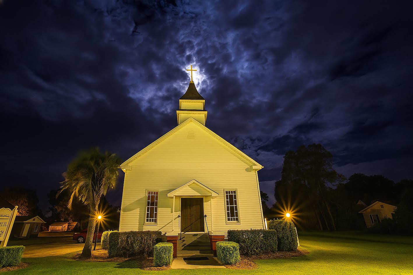 Lake Park Christian Church lit up at night with cross-topped steeple